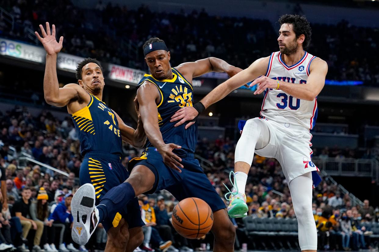 Indiana Pacers center Myles Turner (33) kicks away the pass from Philadelphia 76ers guard Furkan Korkmaz (30) during the first half of an NBA basketball game in Indianapolis, Saturday, Nov. 13, 2021.