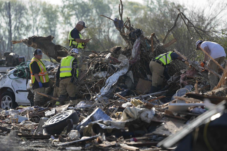 Emergency rescuers and first responders climb through a tornado demolished mobile home park looking for bodies that might be buried in the piles of debris, insulation, and home furnishings, Saturday morning, March 25, 2023, in Rolling Fork, Miss. Emergency officials in Mississippi say several people have been killed by tornadoes that tore through the state on Friday night, destroying buildings and knocking out power as severe weather produced hail the size of golf balls moved through several southern states. (AP Photo/Rogelio V. Solis)