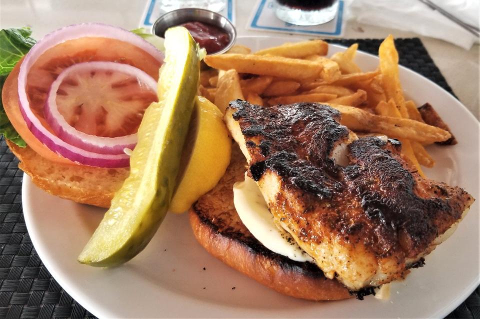 The grouper sandwich at Beach House in Bradenton Beach on Anna Maria Island is blackened grouper, with lemon aioli, lettuce, tomato and red onion on a fresh baked bun served with a side of fries.