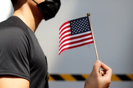 An anti-government protester holds a US flag during a rally at the University of Hong Kong