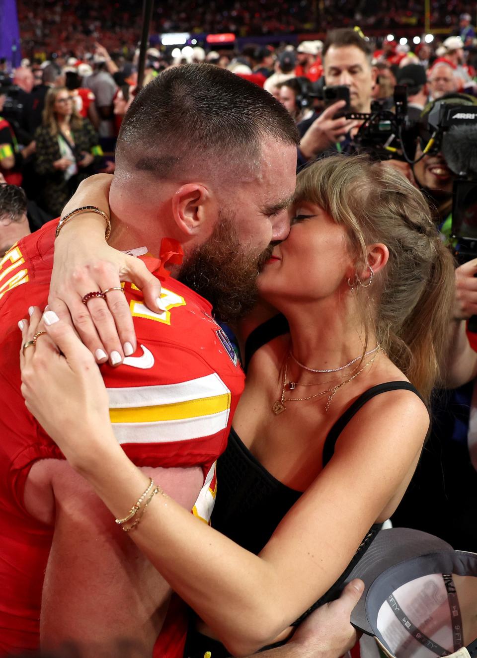 Travis and Taylor kissing after a Chiefs game