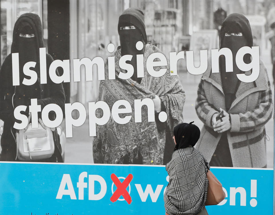 A woman with a headscarf walks past an AfD campaign poster in Marxloh, a suburb of Duisburg, Germany, in which many people have Turkish roots. (Photo: Wolfgang Rattay / Reuters)