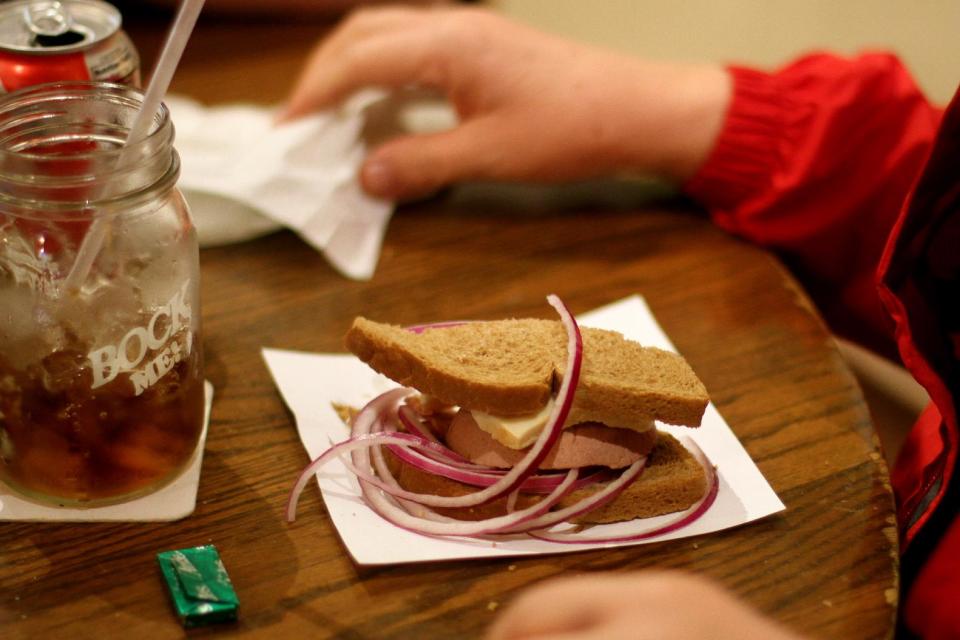This April 19, 2013 photo shows a diner at Baumgartner's Cheese Store and Tavern in Monroe, Wis., enjoying a Limburger cheese sandwich. Monroe is the only place in the United States where the famed "stinky cheese" is still produced. (AP Photo/Niamh O'Neill-Culhane)