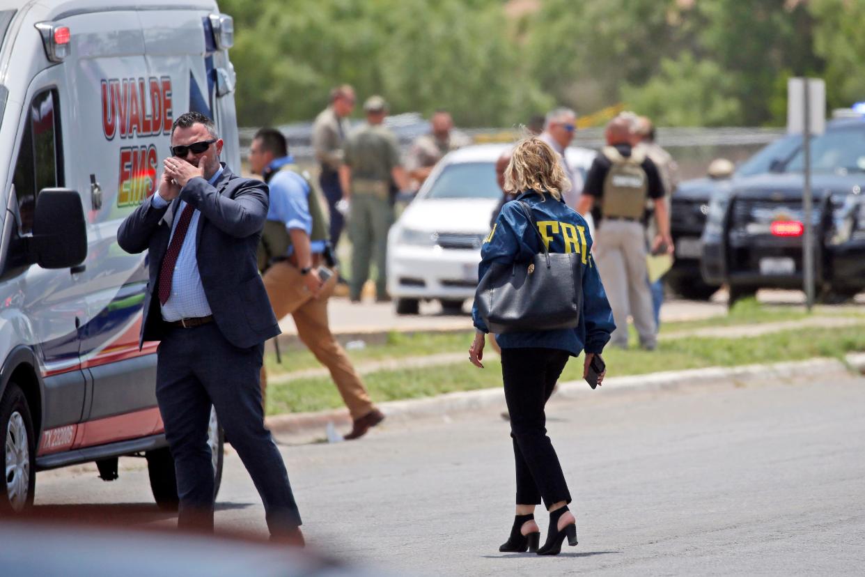 Law enforcement personnel, including the FBI, gather near Robb Elementary School following a shooting, Tuesday, May 24, 2022, in Uvalde, Texas. 