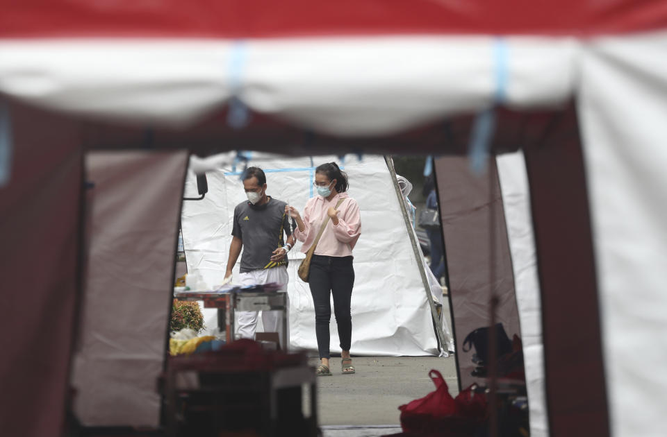 A patient its assisted to an emergency tent erected to accommodate a surge of COVID-19 patients at a hospital in Bekasi, West Java, Indonesia, Monday, June 28, 2021. (AP Photo/Achmad Ibrahim)