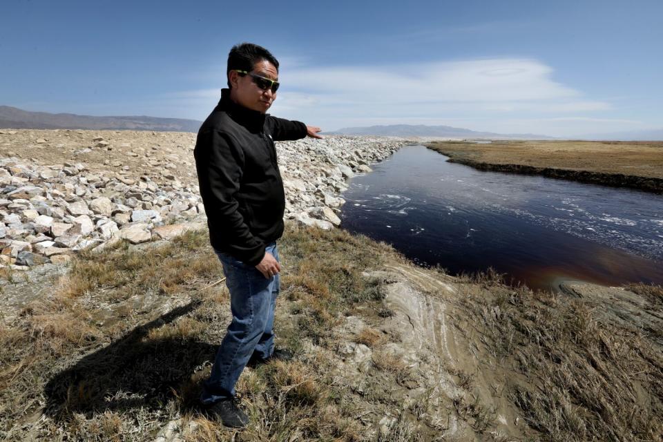 A man gestures toward a water channel