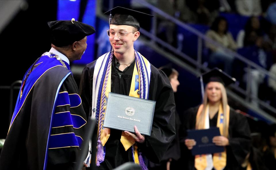 MTSU graduate Nolan Willis Jr. shakes the hand of MTS President Sidney McPhee as he accepts his diploma and walks across the stage during MTSU’s 2023 Fall Graduation Ceremony on Saturday, Dec. 16, 2023.