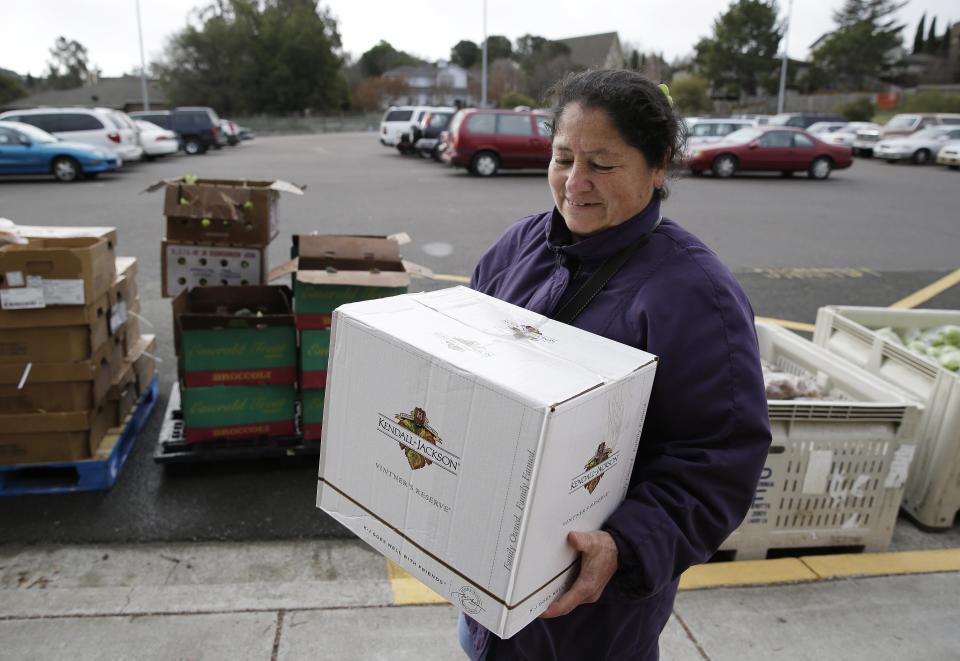 This photo taken Jan. 8, 2014 shows Maria Gonzalez carrying away her specially prepared box of food at a food bank distribution in Petaluma, Calif., part of a research project with Feeding America to try to improve the health of diabetics in food-insecure families. Doctors are warning that the federal government could be socked with a bigger health bill if Congress cuts food stamps _ maybe not immediately, they say, but if the poor wind up in doctors' offices or hospitals as a result. (AP Photo/Eric Risberg)