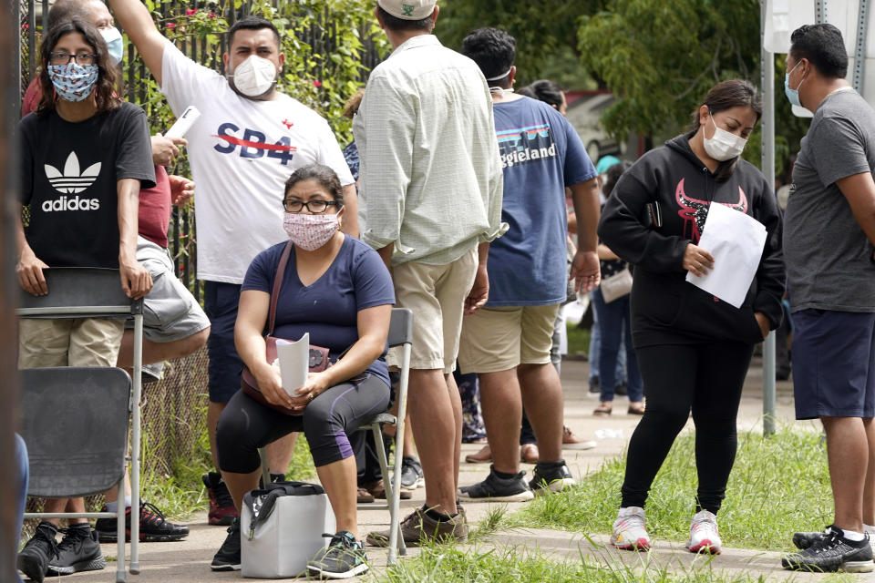 People wait in line at a free COVID-19 testing site provided by United Memorial Medical Center, at the Mexican Consulate, Sunday, June 28, 2020, in Houston. Confirmed cases of the coronavirus in Texas continue to surge. Texas Gov. Greg Abbott, on Friday, shut down bars again and scaled back restaurant dining as cases climbed to record levels after the state embarked on one of America's fastest reopenings. (AP Photo/David J. Phillip)