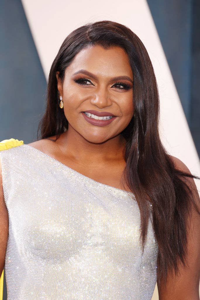 A closeup of a smiling Mindy who's wearing a one-shoulder sequined gown