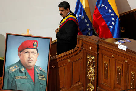 FILE PHOTO: Venezuela's President Nicolas Maduro walks next to a painting of Venezuela's late President Hugo Chavez, during a special session of the National Constituent Assembly to present his annual state of the nation in Caracas, Venezuela January 14, 2019. REUTERS/Manaure Quintero/File Photo