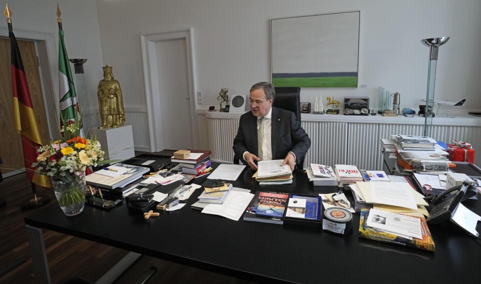 Governor of North Rhine-Westphalia Armin Laschet sits at his desk after an interview with the Associated Press at his office in Duesseldorf, Germany, Wednesday, June 30, 2021. Laschet, the 60-year-old governor of Germany's most populous state, is the front-runner to succeed Angela Merkel as chancellor in the country's Sept. 26 election. (AP Photo/Martin Meissner)