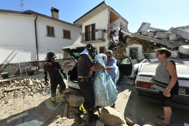 Firefighters help residents to recover their personal belongings from damaged houses in the village of Rio, some 10 kms from the central Italian village of Amatrice, on August 28, 2016