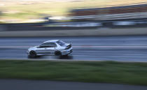 A car races down the quarter-mile track at Bandimere Speedway west of Denver on May 5, 2021. The Colorado State Patrol runs a program called "Take it to the Track" in hopes of luring racers away from public areas to a safer and more controlled environment, even allowing participants to race a trooper driving a patrol car. The program's goals have gained new importance and urgency this year as illegal street racing has increased amid the coronavirus pandemic. (AP Photo/Thomas Peipert)