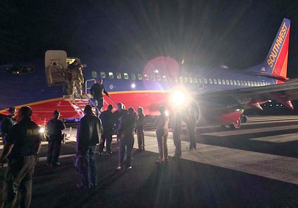 In this Sunday, Jan. 12, 2014 photo provided by Scott Schieffer, passengers exit a Southwest Airlines flight that was supposed to land at Branson Airport in Branson, Mo., but instead landed at Taney County Airport, in Hollister, Mo., that only has about half as much runway. A Southwest spokesman said all 124 passengers and five crew members were safe. (AP Photo/ Scott Schieffer) MANDATORY CREDIT