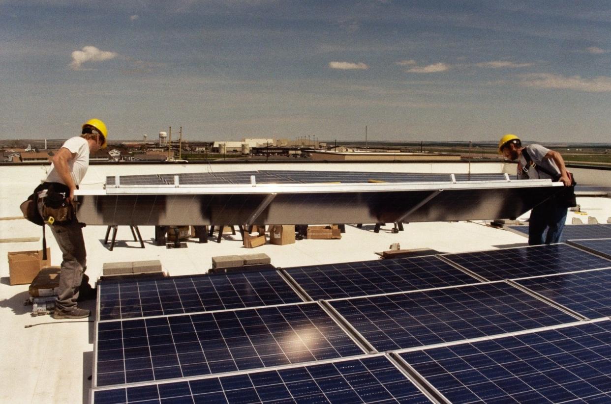 Workers from Bozeman Green Build install solar panels on the roof of the U.S. Armed Forces Reserve Center in Great Falls.