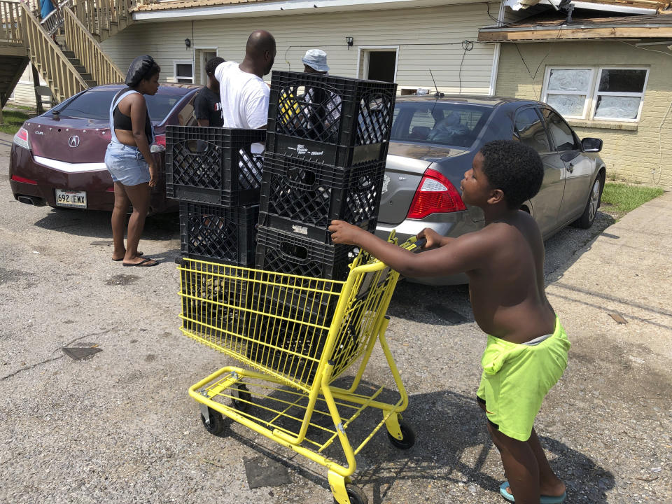 Christopher Williams, 5, pushes a shopping cart outside his family's destroyed apartment in Luling, La., on Tuesday, Sept. 7, 2021. Williams, and his two brothers stack milk crates in a vacant parking lot to pass time because their toys were swept away by Hurricane Ida. They are among an estimated 250,000 children across Louisiana with no school to go to after the storm left them shuttered. (AP Photo/Matt Sedensky)
