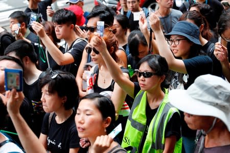 Journalists hold up their press cards as they stage a silent march to Police Headquarters to denounce media treatment during protest against a proposed extradition bill, in Hong Kong