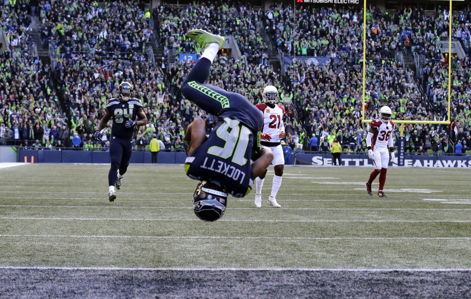 Seattle Seahawks' Tyler Lockett (16) flips his way into the end zone on a 29-yard touchdown reception against the Arizona Cardinals during the first half of an NFL football game, Sunday, Dec. 30, 2018, in Seattle. (AP Photo/John Froschauer)