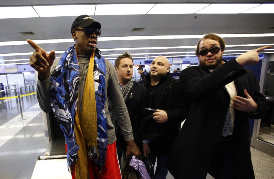 Former NBA basketball player Dennis Rodman gestures as he leaves for Pyongyang from Beijing International Airport