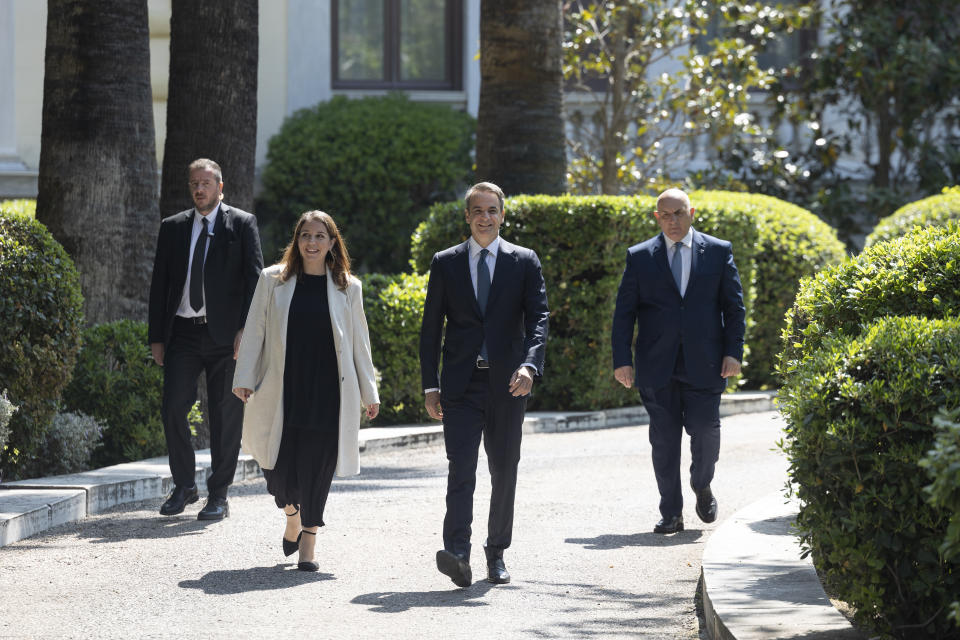 Greece's Prime Minister Kyriakos Mitsotakis, second right, leaves the Presidential palace following a meeting with Greek President Katerina Sakellaropoulou, in Athens, Saturday, April 22, 2023. Mitsotakis visited the Greek President to officially announce a general election on May 21. (AP Photo/Yorgos Karahalis)