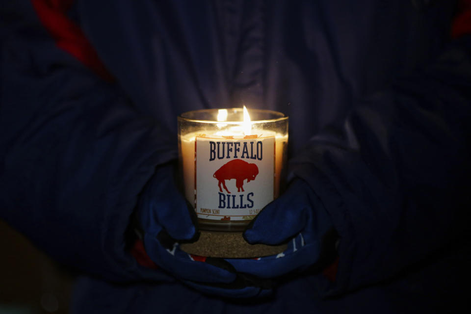 FILE - A person holds a Buffalo Bills candle during a a candlelight vigil for Bills safety Damar Hamlin on Tuesday, Jan. 3, 2023, in Orchard Park, N.Y. The Buffalo Bills have been a reliable bright spot for a city that has been shaken by a racist mass shooting and back-to-back snowstorms in recent months. So when Bills safety Damar Hamlin was critically hurt in a game Monday, the city quickly looked for ways to support the team. (AP Photo/Joshua Bessex, File)