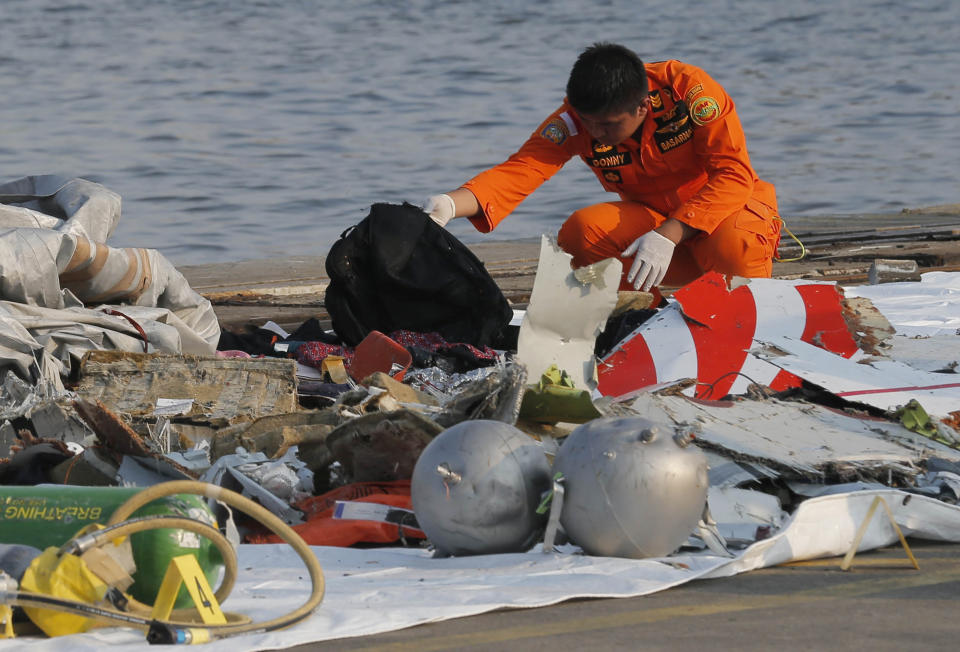 A member of Indonesian Search and Rescue Agency (BASARNAS) inspects debris believed to be from Lion Air passenger jet that crashed off Java Island at Tanjung Priok Port in Jakarta, Indonesia Monday, Oct. 29, 2018. A Lion Air flight crashed into the sea just minutes after taking off from Indonesia's capital on Monday in a blow to the country's aviation safety record after the lifting of bans on its airlines by the European Union and U.S. (AP Photo/Tatan Syuflana)