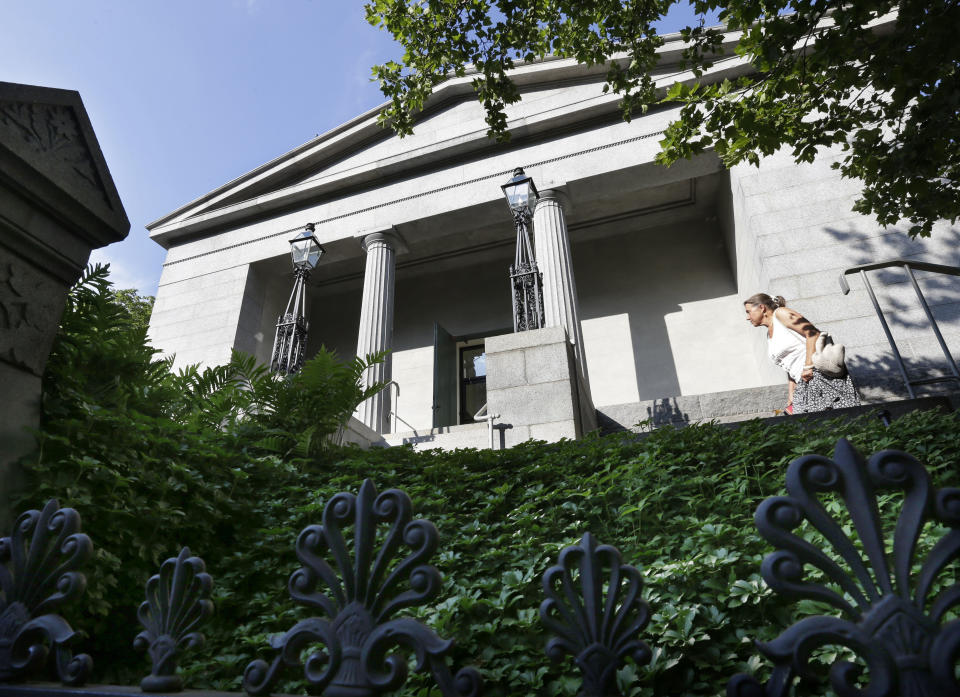 A woman enters the Providence Athenaeum, in Providence, R.I., Monday, July 15, 2013. With roots dating back to 1753, the private library is one of the oldest in the country. It is housed in a Greek Revival-style granite building that neighbors Brown University and the Rhode Island School of Design. (AP Photo/Steven Senne)