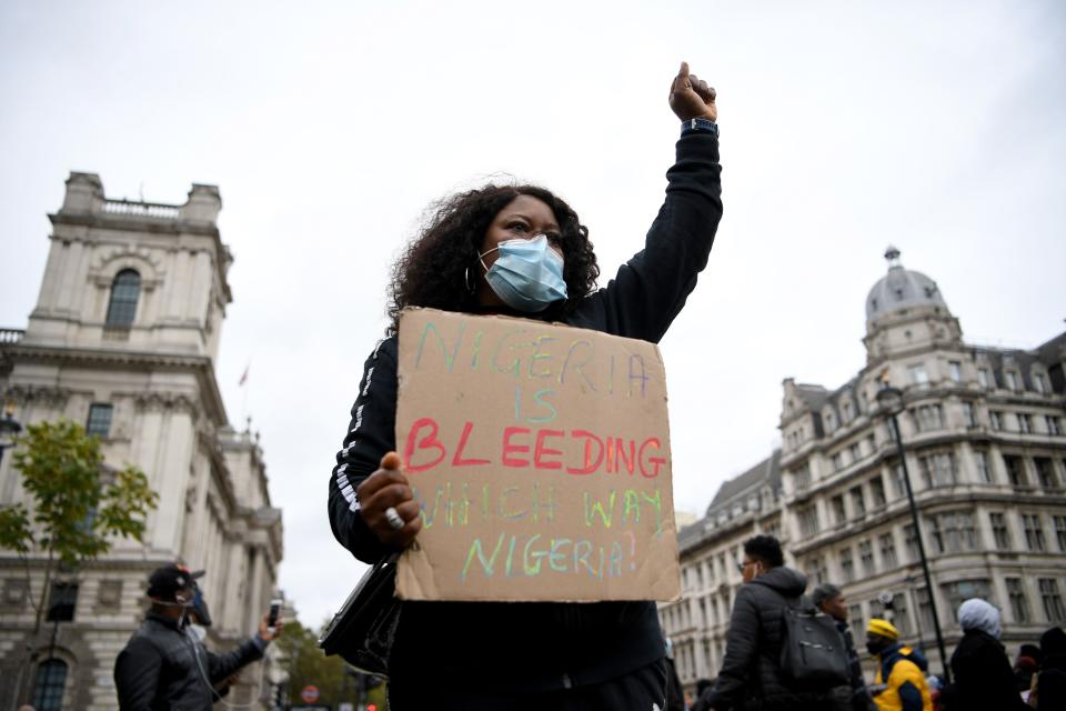 Protesters carry placards in Parliament Square in London on Oct. 24, 2020, to put pressure on Nigeria as UN Secretary General Antonio Guterres has called for an end to what he called "brutality" by police in Nigeria.