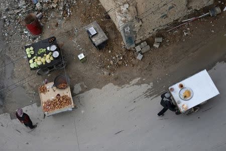 Men sell produce on their carts in the rebel held besieged city of Douma, a suburb of Damascus, Syria February 23, 2016. Picture taken February 23, 2016. REUTERS/Bassam Khabieh