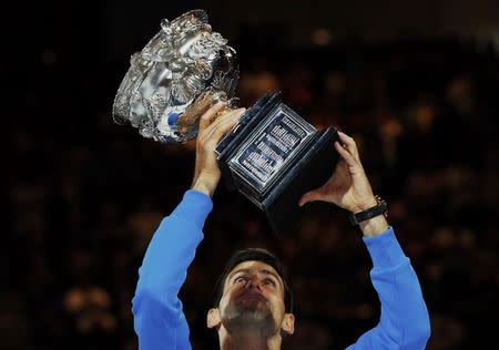 Novak Djokovic of Serbia holds up his trophy after defeating Andy Murray of Britain in their men's singles final match at the Australian Open 2015 tennis tournament in Melbourne February 1, 2015. REUTERS/Issei Kato