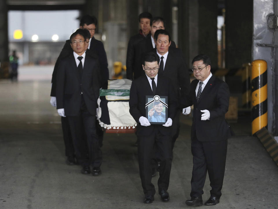 Relatives and friends of the late mountain climber Kim Chang-ho carry his portrait and the casket containing his body from a cargo terminal at Incheon International Airport in Incheon, South Korea, Wednesday, Oct. 17, 2018. Relatives dressed in black funeral suits wept in grief on Wednesday as the bodies of five South Korean mountain climbers arrived home from Nepal where they had died in a storm last week. (Lee Ji-eun/Yonhap via AP)