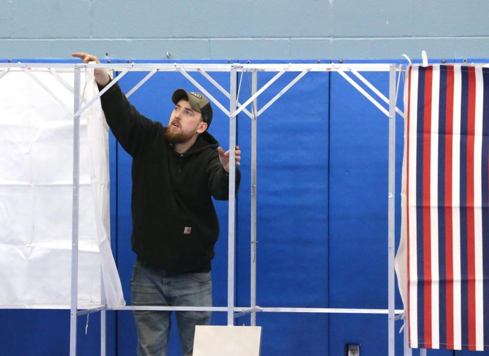 Durham public works employee Chris Starkweather helps set up the polling station at Oyster River High School Tuesday Jan. 22, 2024, a day before the New Hampshire primary.