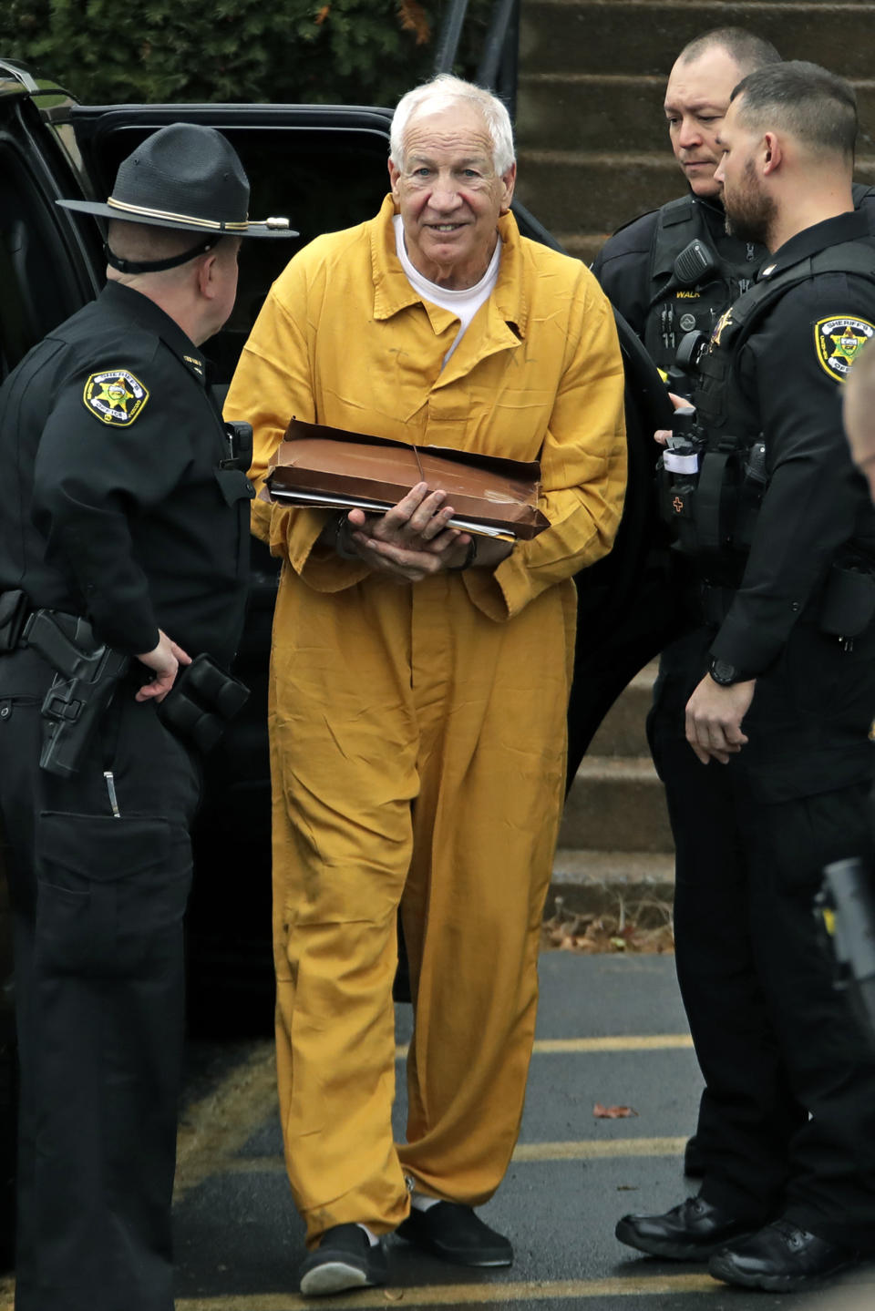 Former Penn State University assistant football coach Jerry Sandusky, center, arrives at the Centre County Courthouse, Friday, Nov. 22, 2019, in Bellefonte, Pa., to be resentenced after an appeals court said mandatory minimum sentences had been improperly applied against him. (AP Photo/Gene J. Puskar)