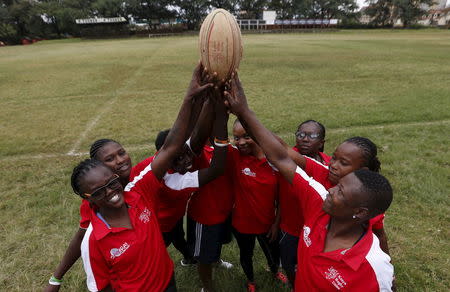 Members of the Kenya Women's Rugby team hold the ball as a team after a light training session at the RFUEA grounds in the capital Nairobi, April 4, 2016. REUTERS/Thomas Mukoya