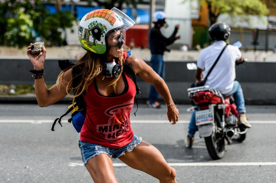 An opposition activist throws an object at riot police on May 1.