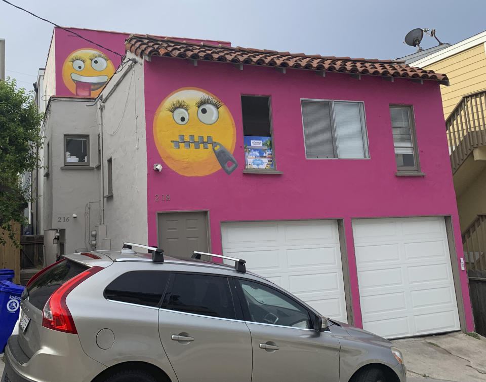 Painted emoji are seen on a house in Manhattan Beach, Calif. on Wednesday, Aug. 7, 2019. The Southern California seaside community is in an uproar after the home was given the new paint job featuring two huge emojis on a bright pink background. Manhattan Beach residents railed against the makeover during a City Council meeting Tuesday night, citing problems with spectators. (AP Photo/Natalie Rice)