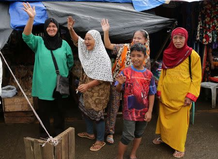 Residents wave at government troops travelling back from their five-month combat duty in Marawi. REUTERS/Romeo Ranoco