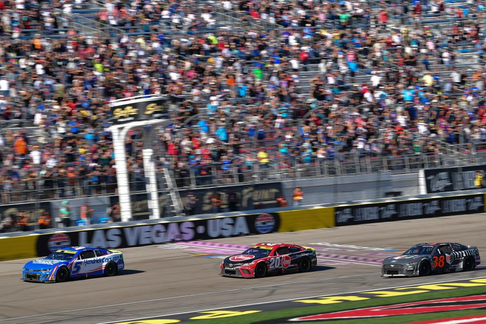 Kyle Larson (5) crosses the finish line ahead of Christopher Bell (20) to win the South Point 400 NASCAR Cup Series playoff race at Las Vegas Motor Speedway on Oct 15, 2023.