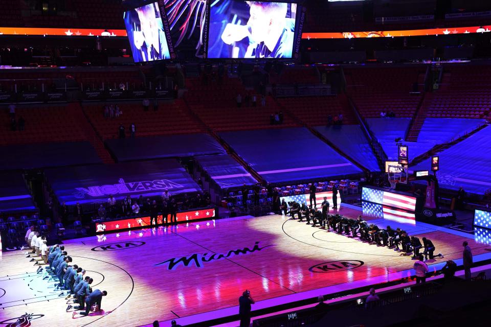 The Boston Celtics and the Miami Heat teams kneel during the playing of the National Anthem before the start of an NBA basketball game, Wednesday, Jan. 6, 2021, in Miami. (AP Photo/Marta Lavandier)