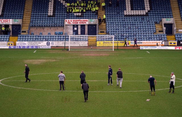 Ground staff work on the pitch 