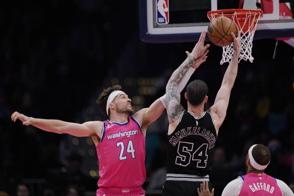 San Antonio Spurs forward Sandro Mamukelashvili (54) goes up against Washington Wizards forward Corey Kispert (24) and center Daniel Gafford (21) during the first half of an NBA basketball game Friday, March 24, 2023, in Washington. (AP Photo/Carolyn Kaster)