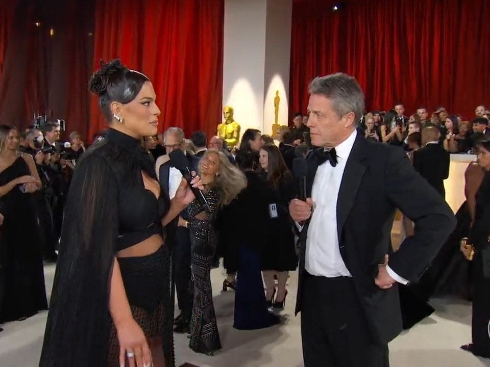 Ashley Graham interviewing Hugh Grant on the red carpet for ABC.