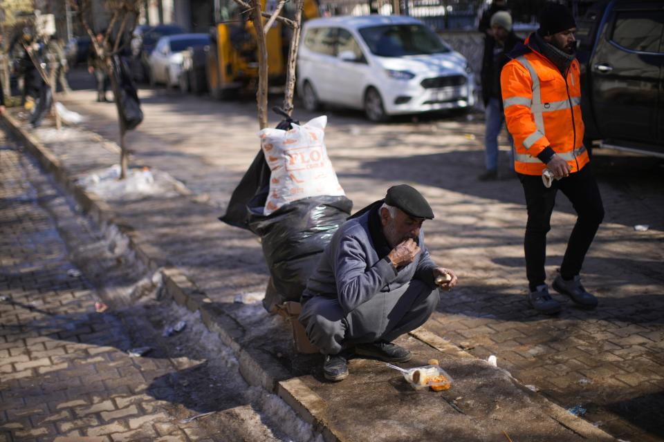 A local man who survived the earthquake eats distributed meal in Golbasi, Turkey, Monday, Feb. 13, 2023. Thousands left homeless by a massive earthquake that struck Turkey and Syria a week ago packed into crowded tents or lined up in the streets for hot meals Monday, while the desperate search for anyone still alive likely entered its last hours. (AP Photo/Francisco Seco)