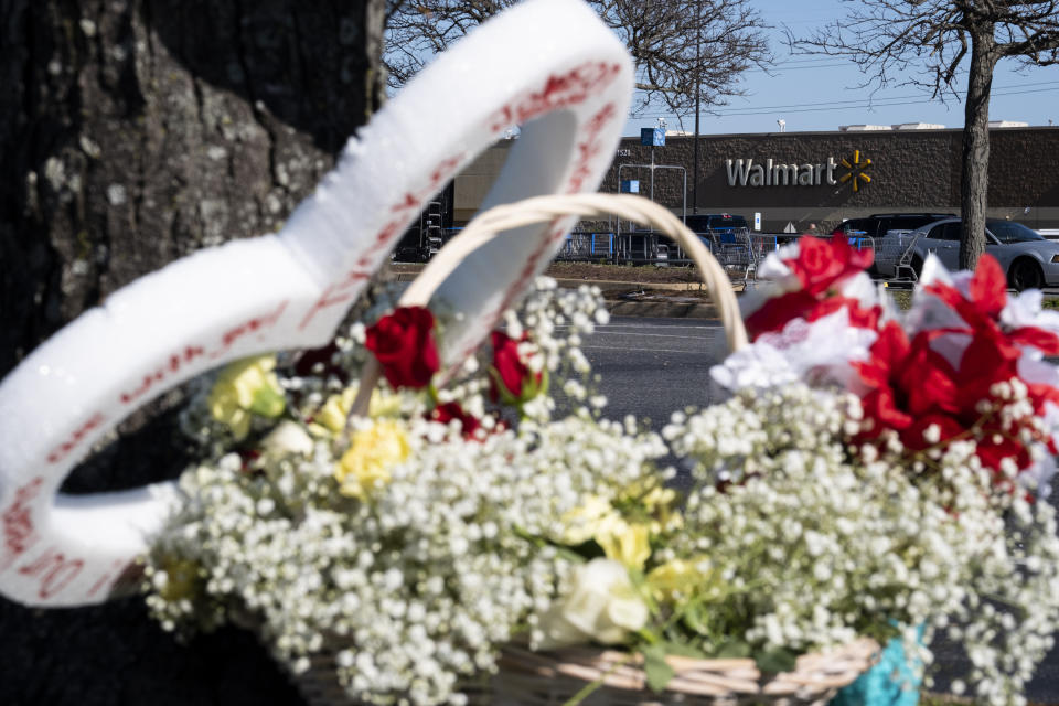 Flowers are placed by a tree outside a Chesapeake, Va. Walmart on Wednesday, Nov. 23, 2022 where a mass shooting took place the night before. (Billy Schuerman/The Virginian-Pilot via AP)