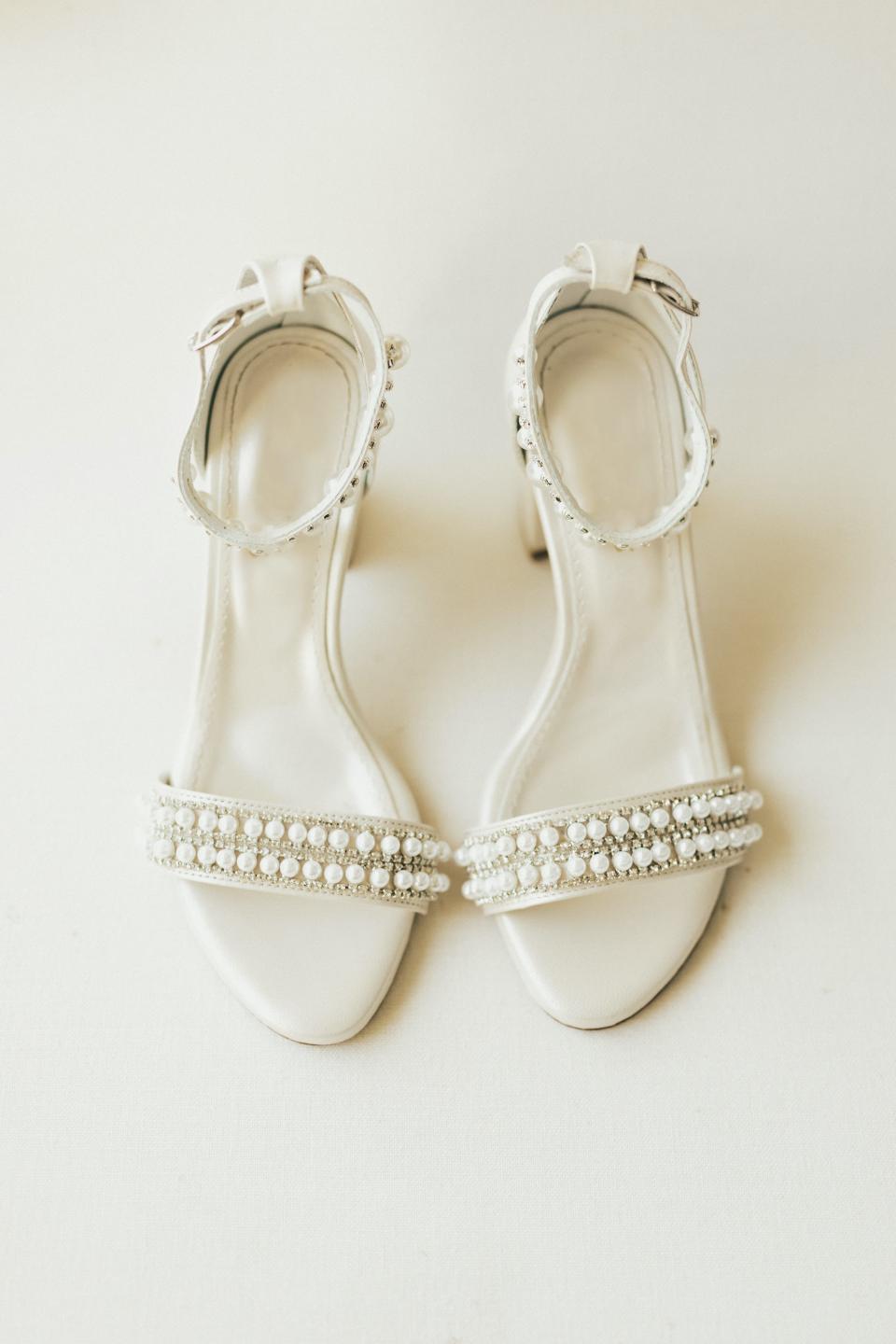 A pair of high heels covered in pearls.