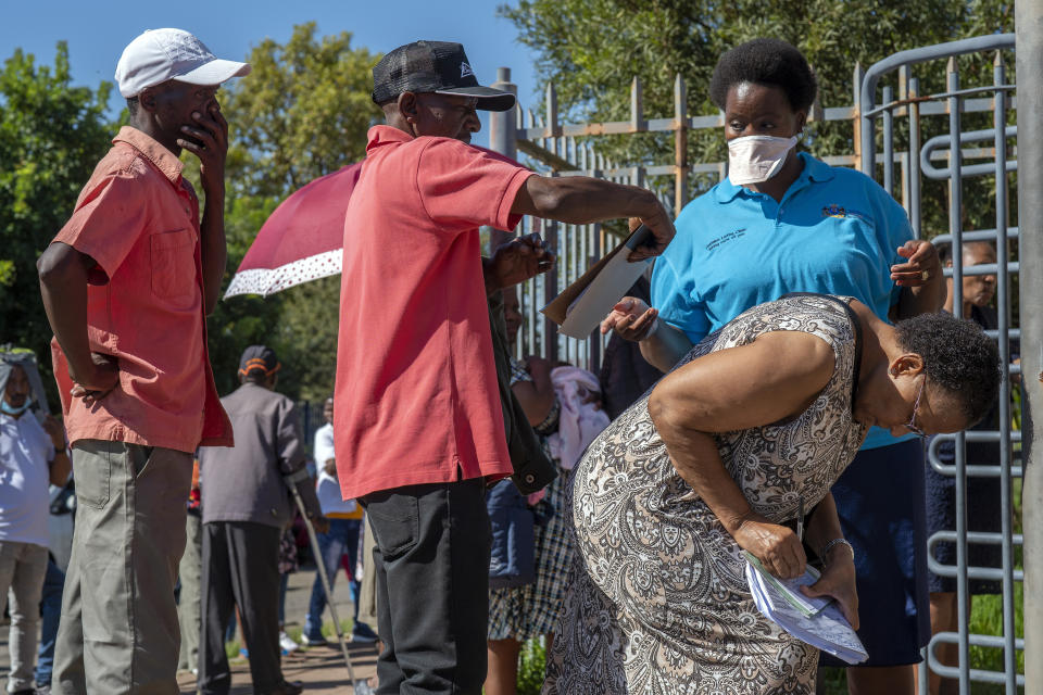 People seeking medical assistance queue outside a local clinic in the township of Soweto, near Johannesburg, South Africa, Thursday March 26, 2020, just hours before South Africa goes into a nationwide lockdown for 21 days, in an effort to control the spread to the coronavirus. The new coronavirus causes mild or moderate symptoms for most people, but for some, especially older adults and people with existing health problems, it can cause more severe illness or death. (AP Photo/Jerome Delay)