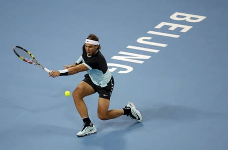 FILE PHOTO: Nadal of Spain hits a return to Djokovic of Serbia during the men's singles final match at the China Open Tennis Tournament in Beijing