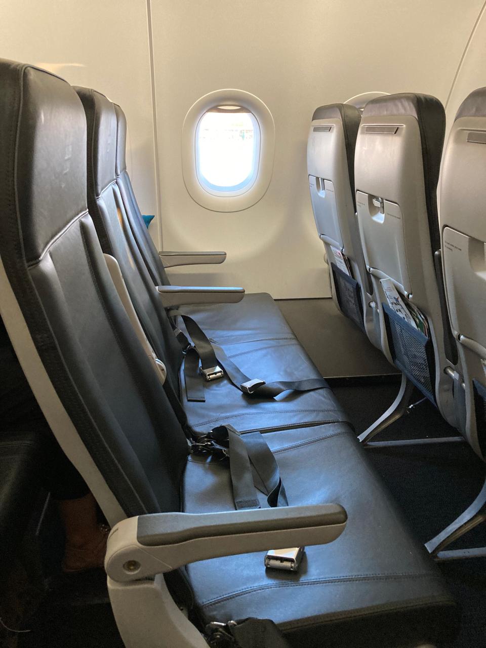 row of three empty airplane seats on frontier airlines