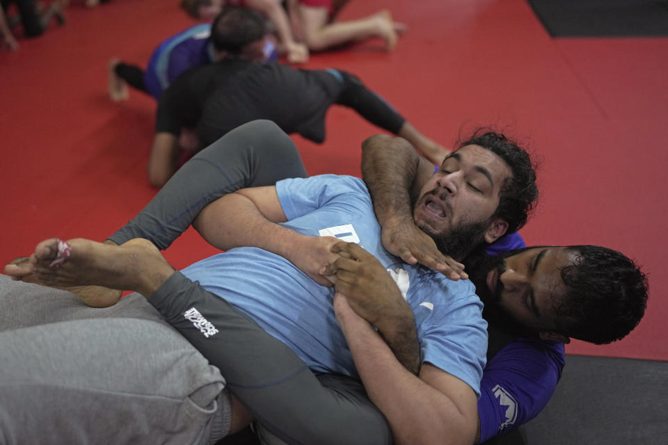 Students practice mixed martial arts moves at Diesel Gym in the Docklands area of East London, Monday, March 25, 2024. The special sessions run by the nonprofit SCK Fitness are held at 10 p.m. during the Muslim holy month of Ramadan to accommodate dawn-to-dusk fasting. (AP Photo/Kin Cheung)